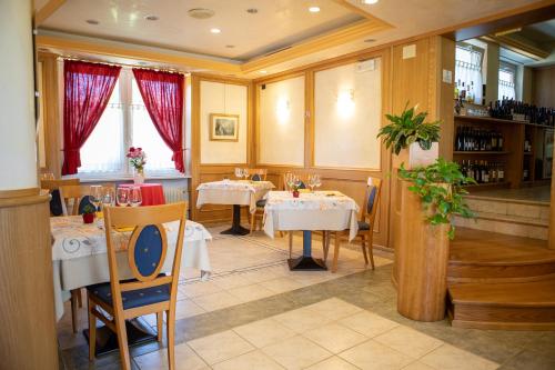 ein Restaurant mit Tischen und Stühlen in einem Zimmer in der Unterkunft Hotel Ristorante Sagittario in Feltre