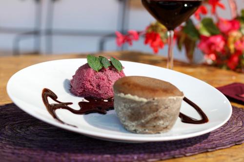 a plate with a pink dessert and a glass of wine at Casa Flora Handmade Hotel in Atlixco