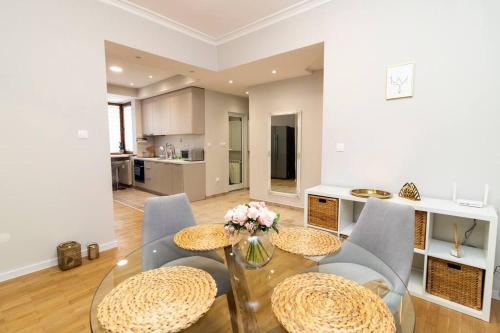 a dining room with a glass table and chairs at Spacious Aristocratic Apt. with a Colourful View in Sofia