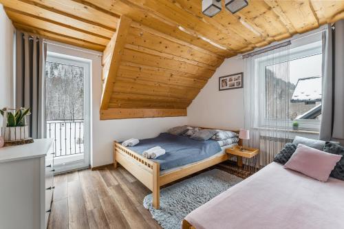 斯塔芙依莎的住宿－Domki Pod Jarmutą，一间卧室设有一张床和两个窗户。