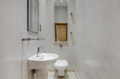 Baño blanco con lavabo y aseo en Care Property London- Apartments, en Londres