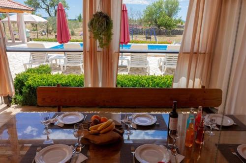 einen Tisch mit Tellern und Weingläsern auf einem Tisch mit Aussicht in der Unterkunft House vacation with pool,near Šibenik in Planjane