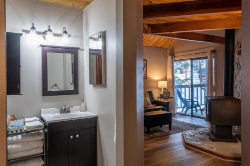 a bathroom with a sink and a mirror and a living room at Escape to Ptarmigan Village 9 in Whitefish