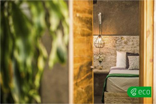 a bedroom with a bed and a lamp on a wall at Casa Flora Handmade Hotel in Atlixco