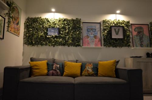 a couch sitting in a living room with plants at Villa Settimia a 50 mt dalla spiaggia! in Àrbatax