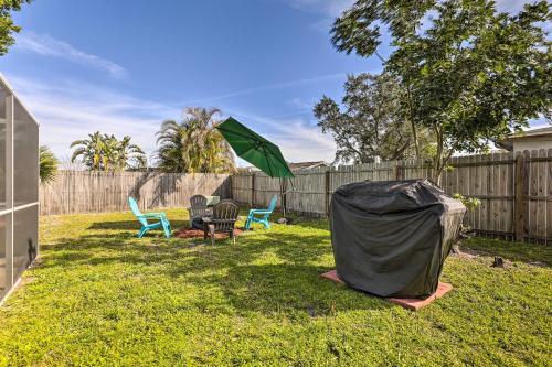 a green tent in a yard with chairs and a fence at Family Home with Lanai and Yard in Port Richey! in Port Richey