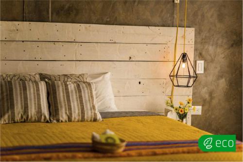 1 dormitorio con 1 cama con cabecero de madera en Casa Flora Handmade Hotel, en Atlixco