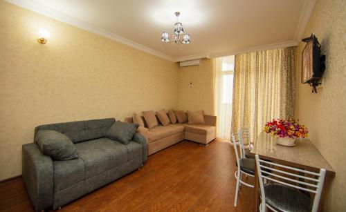 a living room with a couch and a table at Sea Towers Suite in Batumi