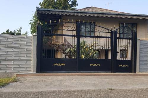 a black gate in front of a house at cheerful 4 bedroom home in Samtredia, georgia (near to airport) in Samtredia