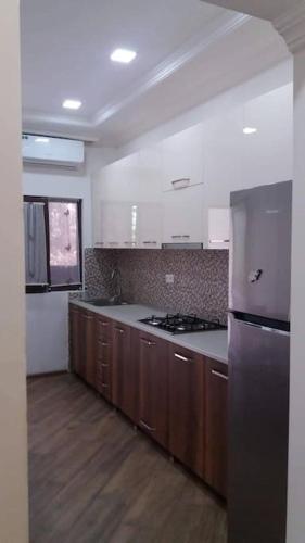 a kitchen with wooden cabinets and a stove top oven at cheerful 4 bedroom home in Samtredia, georgia (near to airport) in Samtredia