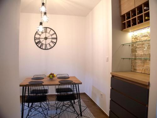 a dining room with a table and a clock on the wall at Adriatic Apartment in Bar