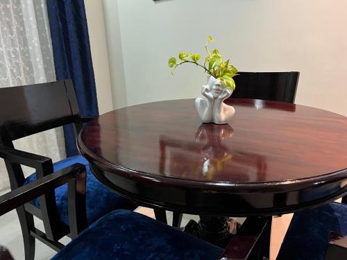 a wooden table with a vase with a plant on it at Serenity Get Away in Lucea