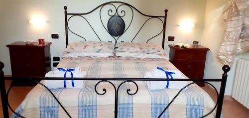 a bedroom with a bed with a wrought iron headboard at Agriturismo L'Uliveto in Gargnano