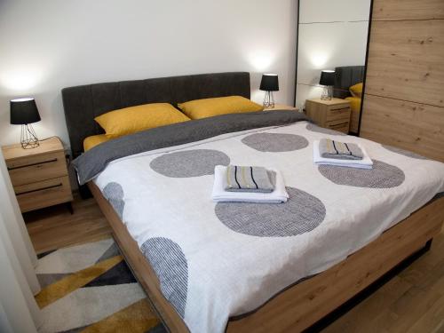 a bedroom with a large bed with two towels on it at Adriatic Apartment in Bar