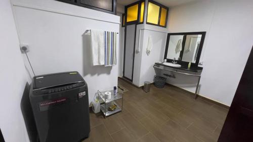 a room with a bathroom with a sink and a refrigerator at AHAVAH in Trou dʼ Eau Douce