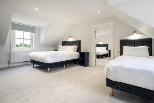 a white bedroom with two beds and a window at THE WHITE HOUSE AT MULLANS BAY in Enniskillen