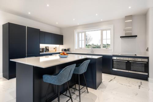 a kitchen with black cabinets and a white counter top at THE WHITE HOUSE AT MULLANS BAY in Enniskillen