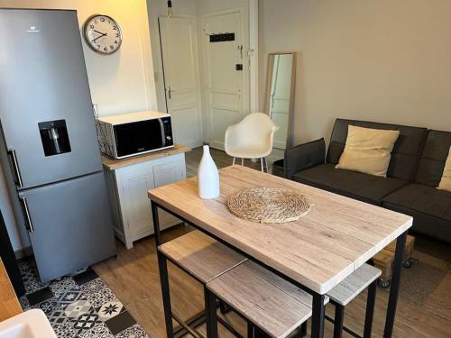 une cuisine et un salon avec une table et un canapé dans l'établissement Appartement cosy avec jardin quartier calme, à Toulouse