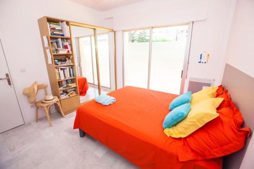 - une chambre avec un lit orange et une étagère dans l'établissement French Riviera: Seafront apt & pool near Monaco, à Roquebrune-Cap-Martin