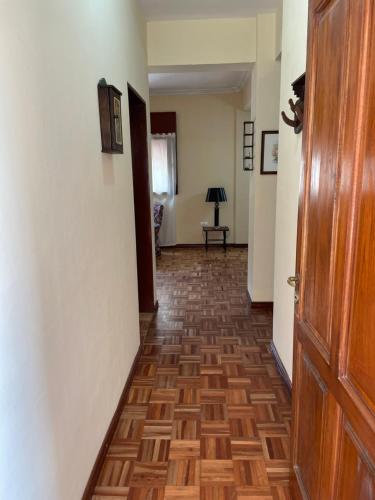 pasillo con suelo de madera y puerta en Departamento Borgoña en Salta