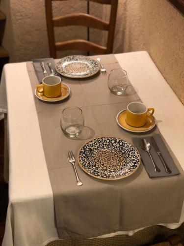a table with two plates and two cups and saucers at Posada Real Mingaseda in Navafría