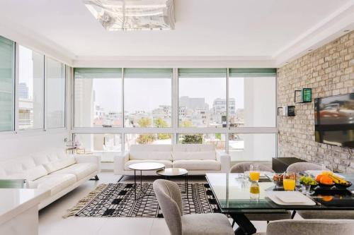 sala de estar con muebles blancos y ventana grande en Into the Jacuzzi by HolyGuest, en Tel Aviv