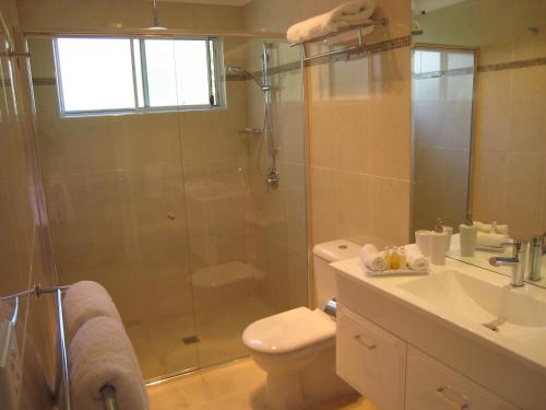 a bathroom with a shower and a toilet and a sink at Brezza Bella Boutique Bed & Breakfast in Merewether