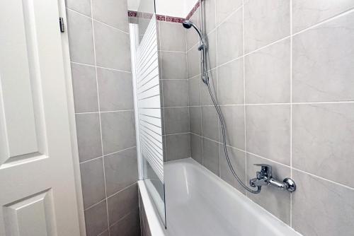 a bathroom with a bath tub and a shower at Ruhiges Office-Apartment mit Küche - BEUYS Apartments Krefeld in Krefeld