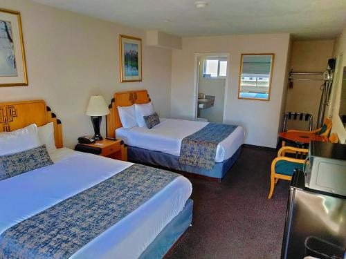 een hotelkamer met 2 bedden en een televisie bij Metropolitan Inn Downtown Salt Lake City in Salt Lake City