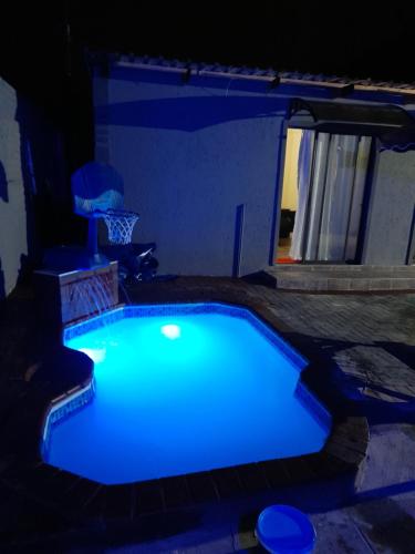 a swimming pool lit up in blue at night at Cozy guesthouse-springs in Springs
