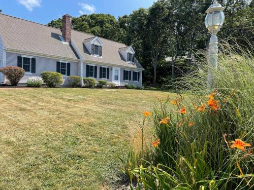 a house with a light pole in the yard at 56Beachway-Private beach Refreshed in 2022 Cozy in East Sandwich