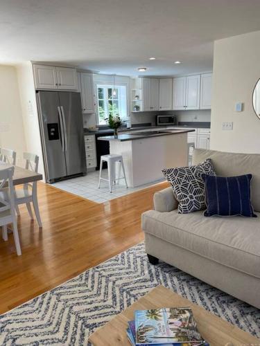 a living room with a couch and a kitchen at 56Beachway-Private beach Refreshed in 2022 Cozy in East Sandwich