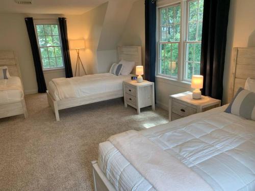1 Schlafzimmer mit 2 Betten und 2 Fenstern in der Unterkunft 56Beachway-Private beach Refreshed in 2022 Cozy in East Sandwich