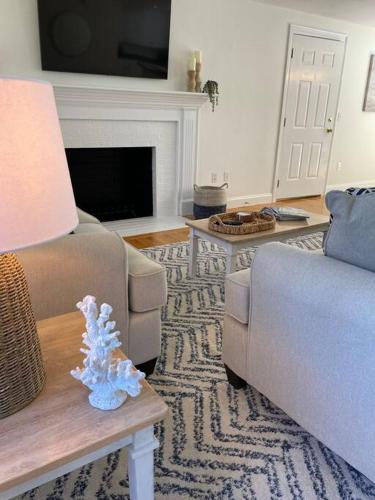 a living room with a couch and a table with a lamp at 56Beachway-Private beach Refreshed in 2022 Cozy in East Sandwich