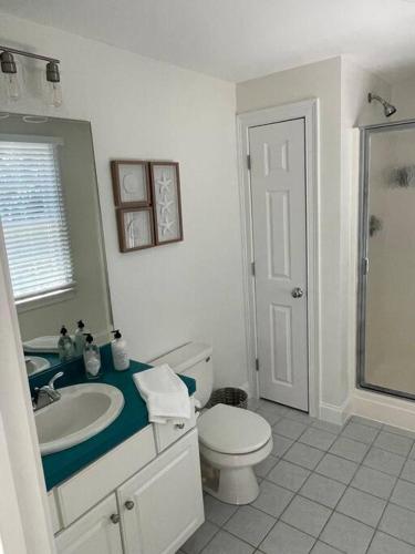 a white bathroom with a sink and a toilet at 56Beachway-Private beach Refreshed in 2022 Cozy in East Sandwich
