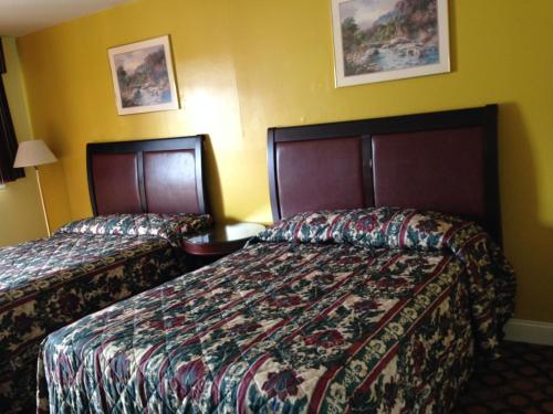 two beds in a hotel room with yellow walls at Flamingo Inn in Seaside Heights