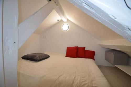 um quarto com uma cama com almofadas vermelhas em Paris chatou brand new quiet cosy flat em Chatou