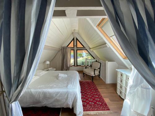 1 dormitorio con 1 cama y 1 silla en el ático en Nature et Lin en Néville