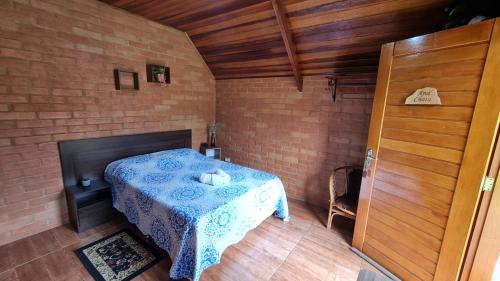 a bedroom with a bed in a brick wall at Chalés Maranata in São Bento do Sapucaí