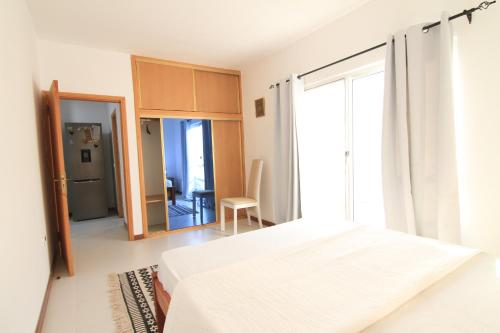 ein Schlafzimmer mit einem Bett und einem großen Fenster in der Unterkunft Quick Stay in Praia #2 in Praia