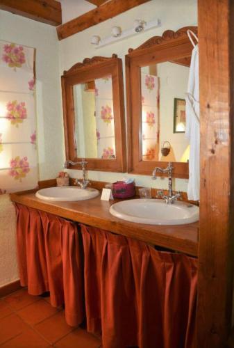 a bathroom with two sinks and two mirrors at Posada Real Mingaseda in Navafría