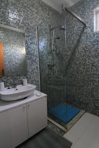 ein Bad mit einer Dusche und einem Waschbecken in der Unterkunft Quick Stay in Praia #2 in Praia