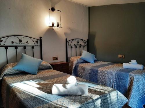 Habitación con 2 camas y toallas. en Vivienda Turística El Acebuchal en Ubrique