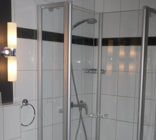 um chuveiro com uma porta de vidro na casa de banho em Gästehaus Zum Lamm em Lauda-Königshofen