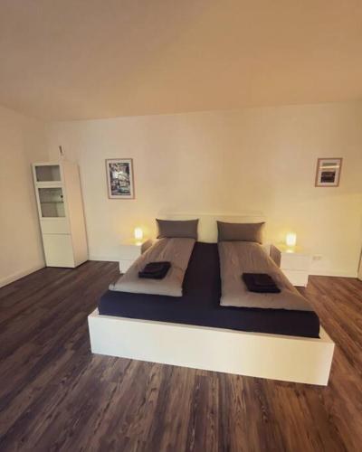un grande letto in una camera con pavimenti in legno di EXKLUSIVES Loft an der Weserpromenade und Stadt a Brema