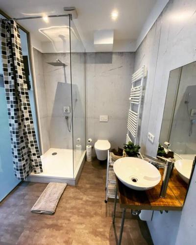 bagno con 2 lavandini, doccia e servizi igienici di EXKLUSIVES Loft an der Weserpromenade und Stadt a Brema