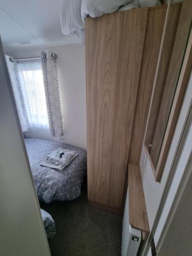 a small room with a bed and a wooden cabinet at "Malton" LG27 Pet Friendly in Shanklin