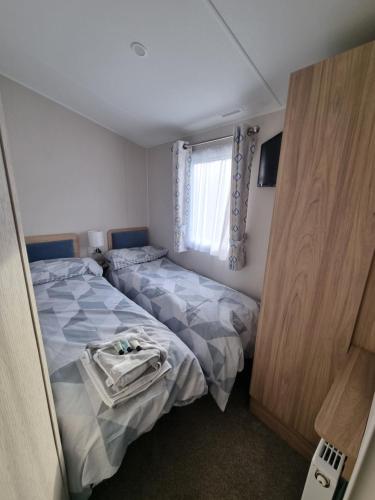 a bedroom with two beds and a window at "Malton" LG27 Pet Friendly in Shanklin
