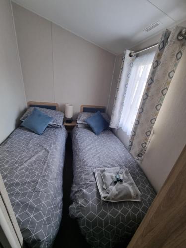 a small bedroom with two beds and a window at "Malton" LG27 Pet Friendly in Shanklin