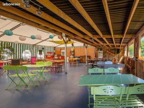 une pièce avec des tables et des chaises dans un bâtiment dans l'établissement Oh! Campings - Camping Paradis A l'ombre des tilleuls, à Peyrouse